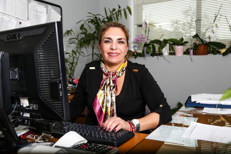 a woman smiles sitting behind a desk